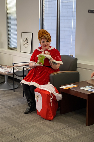 Melissa Bolster as Ms. Claus handing out gifts